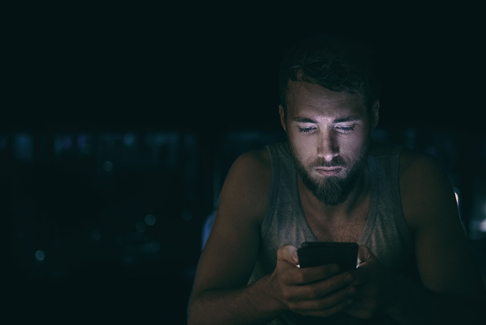 A man looks up addiction recovery resources on his cell phone