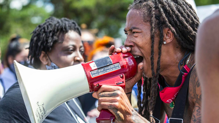 African-American man speaking into a megaphone during a protest