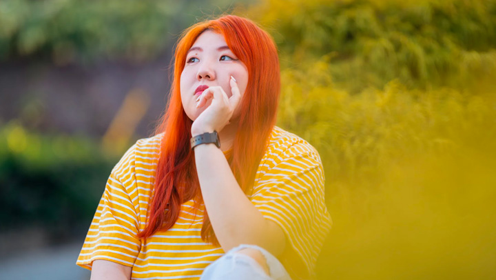 A girl sitting outside thinking