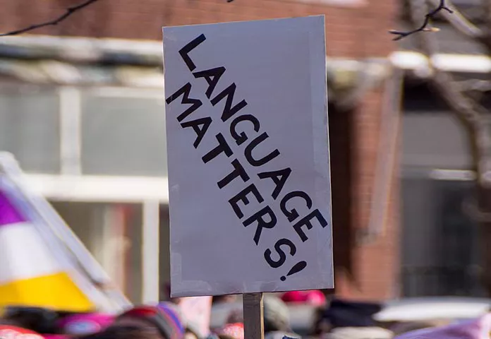 A white sign with black text that reads "Language Matters!"