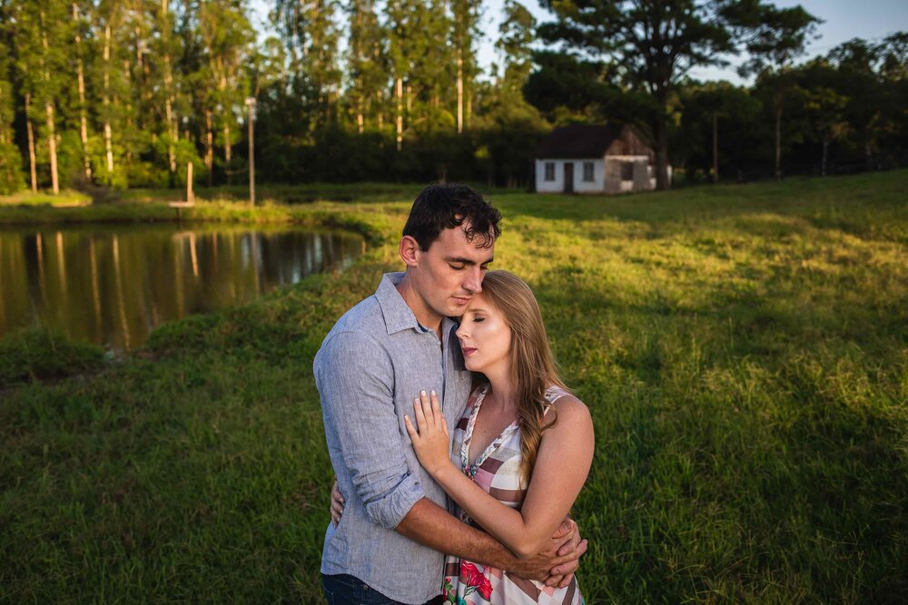 A man and a woman comfort each other outside near a pond through their addiction recovery journey