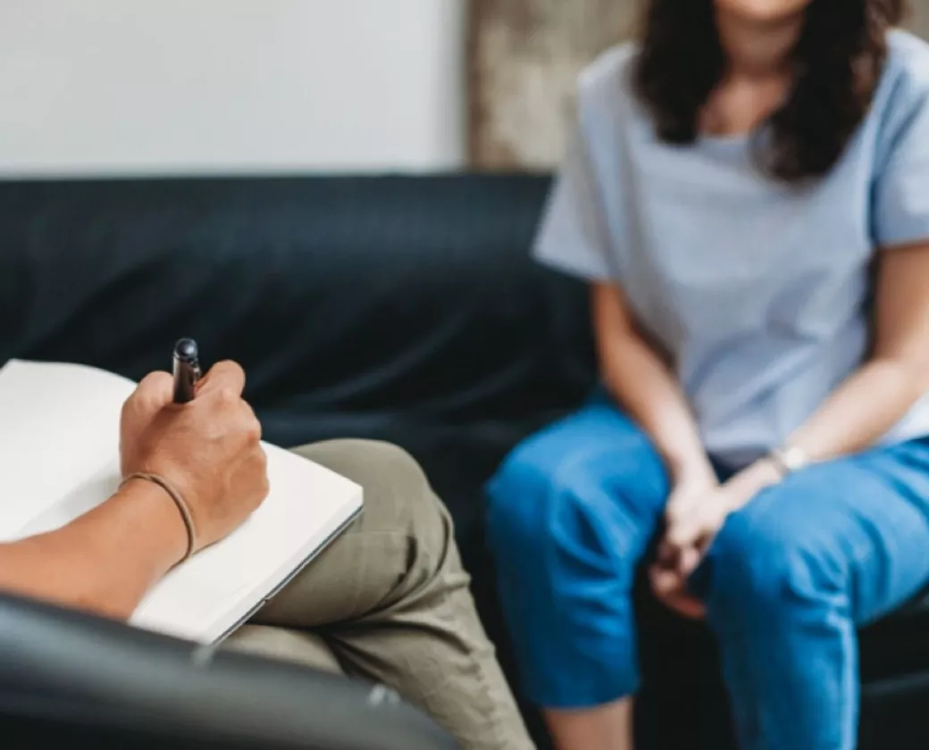 A woman concerned with substance use and mental health meets with a therapist