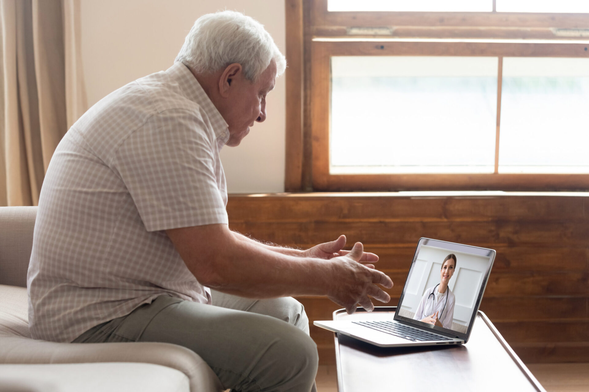 Elderly man at a laptop doing a telehealth session