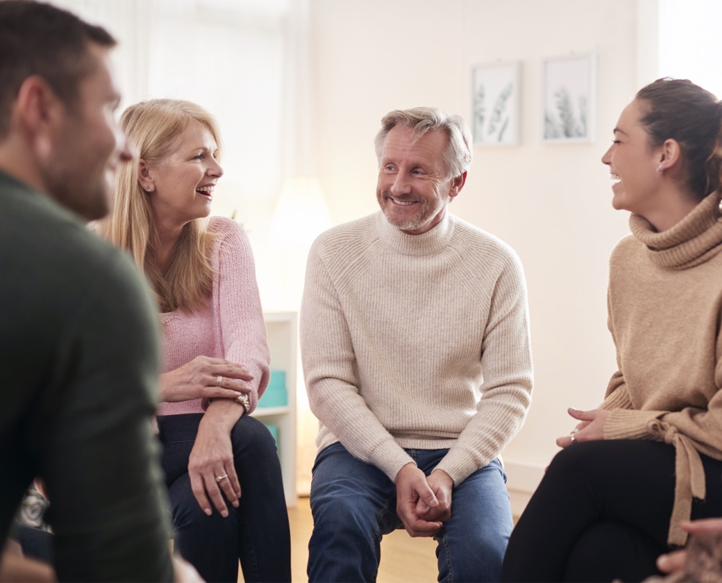 People talk during a group therapy session for those affected by addiction