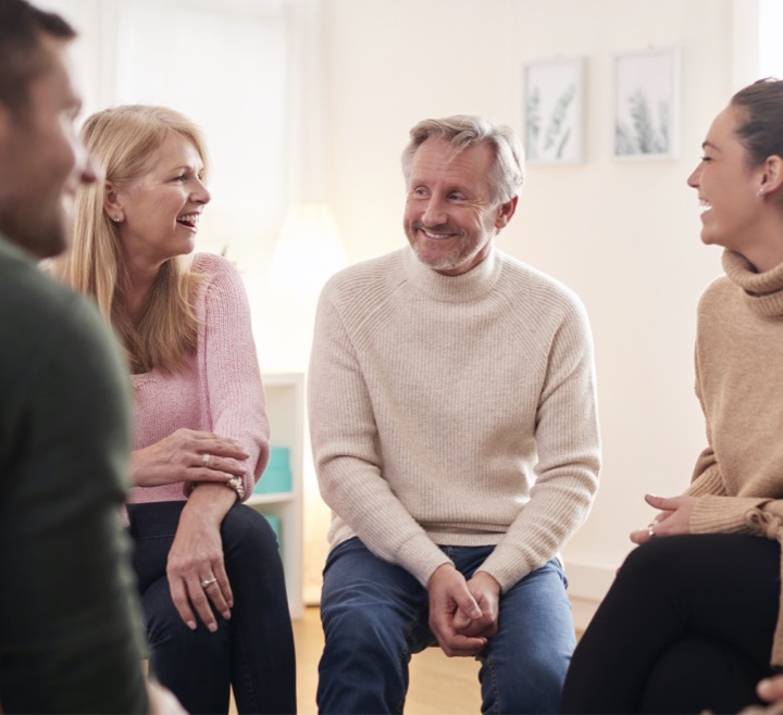 People talk during a group therapy session for those affected by addiction