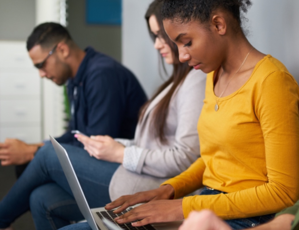 A group of people using a computer and cell phones