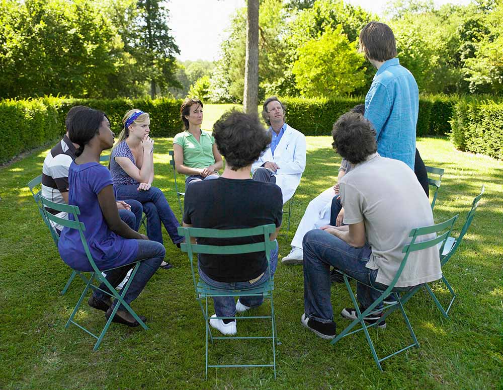 A group of people meet outside for a therapy session
