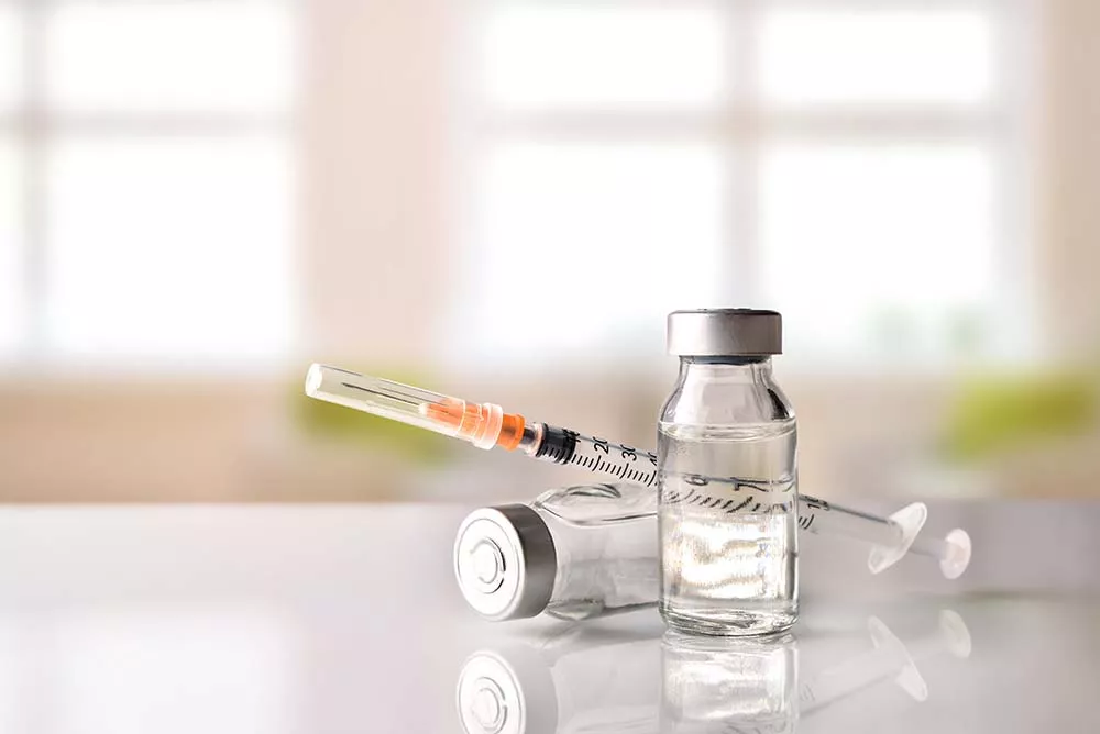 A vial and syringe of vivitrol sit on a countertop