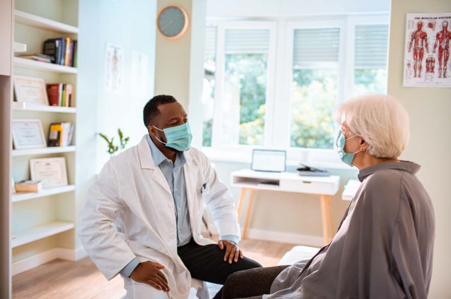 A doctor talks to an elderly patient