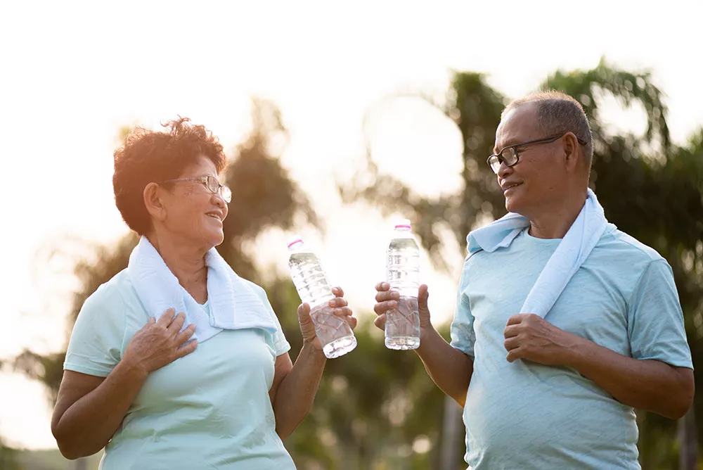 A middle-aged couple chats together while working out