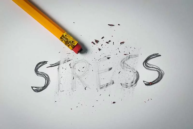 Pencil erasing the word "stress," representing stress management