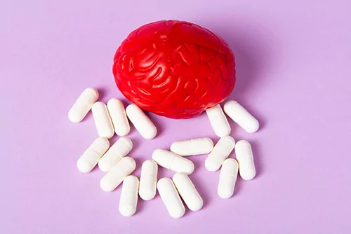 A red toy brain surrounded by SSRI medication