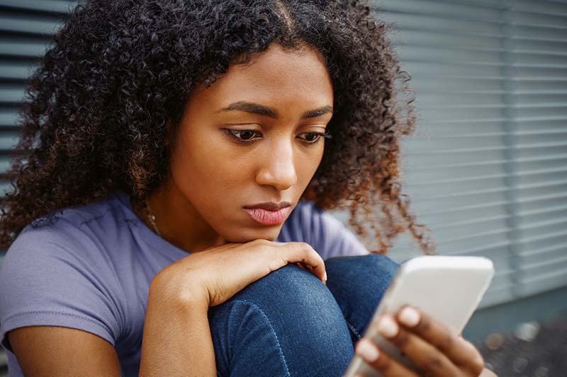 A young girl scrolls through a mental health app