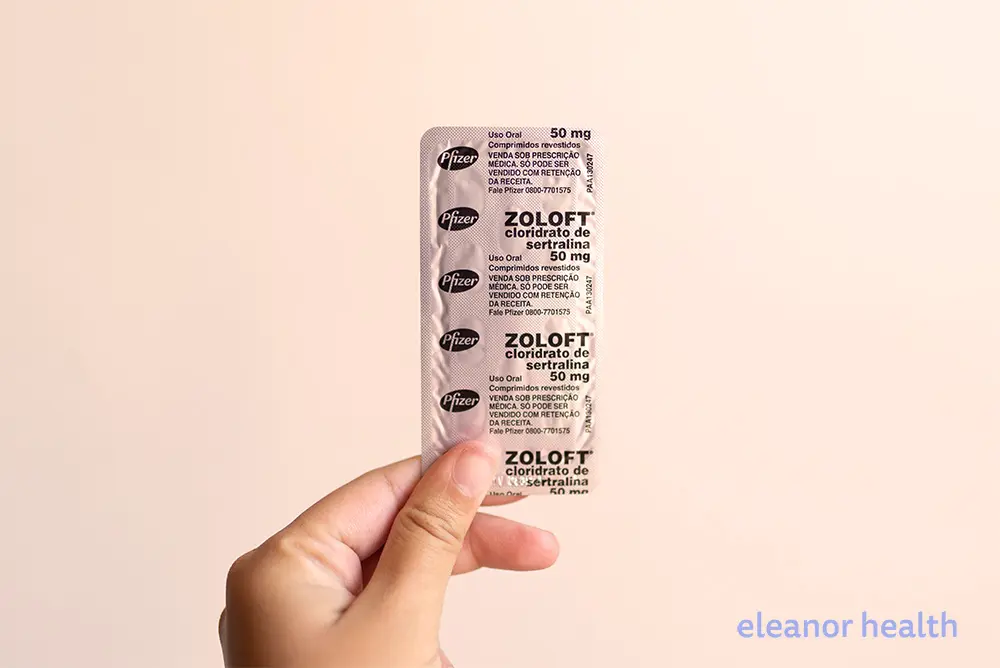 A hand holds up Zoloft or Sertraline tablets for anxiety and depression treatment