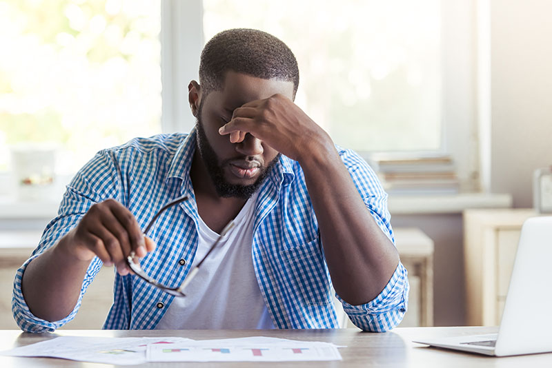 A man rubs his head as a result of stress